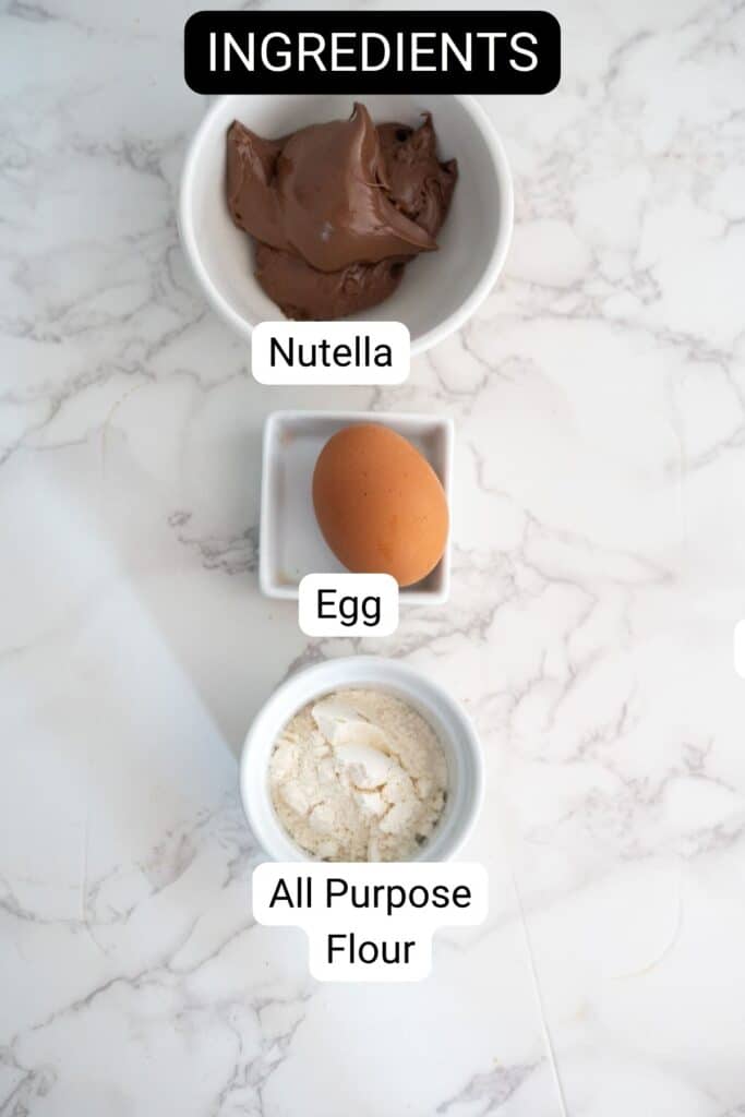 Three labeled bowls on a marble surface containing Nutella, an egg, and all-purpose flour, with the heading "Ingredients" at the top.