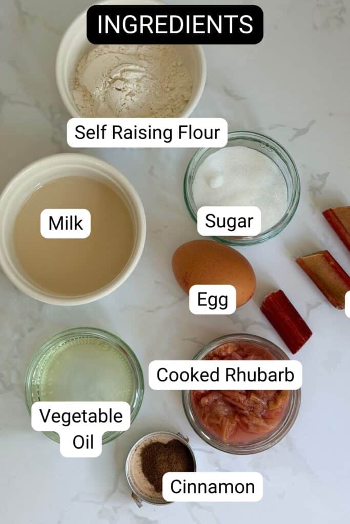 Various baking ingredients labeled: self-raising flour, milk, sugar, egg, cooked rhubarb, vegetable oil, and cinnamon, arranged on a white surface.